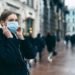 Eine Frau trägt eine Mund-Nasen-Schutzmaske in einer Innenstadt.