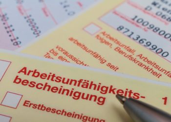 Eine Arbeitsunfähigkeitsbescheinigung und ein Kugelschreiber