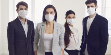 Vier Personen tragen Atemschutzmasken.