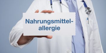 Arzt hält Schil mit der Aufschrift "Nahrungsmittelallergie"
