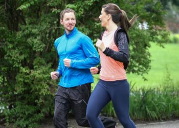 Ein Mann und eine Frau joggen zusammen und unterhalten sich dabei.