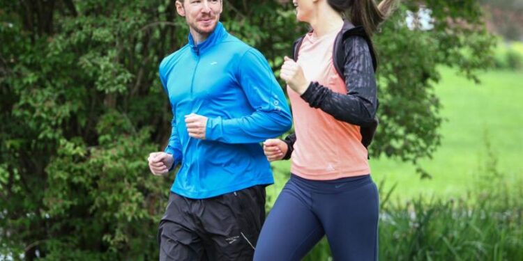 Ein Mann und eine Frau joggen zusammen und unterhalten sich dabei.