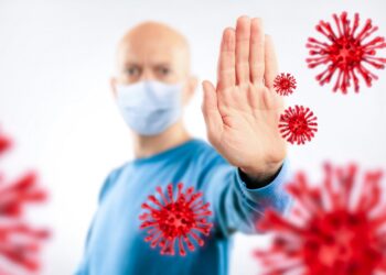 Man mit Mundschutz wehrt illustrierte Viren.