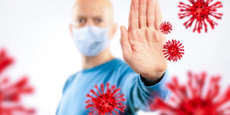 Man mit Mundschutz wehrt illustrierte Viren.