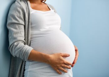 Frau hält ihren Schwangerschaftsbauch