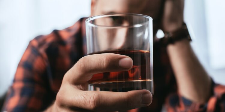 Deprimierter Mann mit einem Glas Whiskey