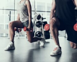 Frau und Mann trainieren im Fitnessstudio mit Hanteln