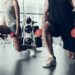 Frau und Mann trainieren im Fitnessstudio mit Hanteln