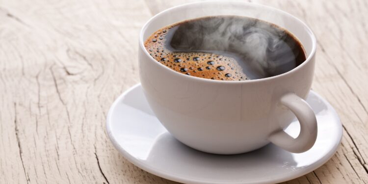 Eine Tasse schwarzer Kaffee auf einem Holztisch