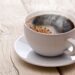 Eine Tasse schwarzer Kaffee auf einem Holztisch