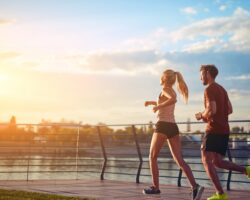 Eine Frau und ein Mann beim Joggen auf einer Brücke