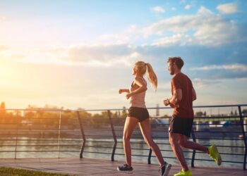 Eine Frau und ein Mann beim Joggen auf einer Brücke