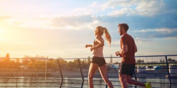 Eine Frau und ein Mann beim Joggen auf einer Brücke