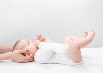 Baby erhält eine osteopathische Behandlung im Nackenbereich