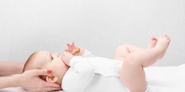 Baby erhält eine osteopathische Behandlung im Nackenbereich
