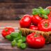 Frische Tomaten und Basilikum in einem Korb auf einem Holztisch