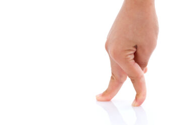 Eine Hand mit kurzen Fingern vor einem weißen Hintergrund.