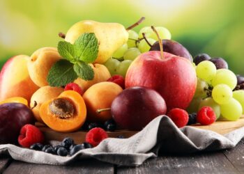 Frische Sommerfrüchte wie Äpfel, Trauben, Beeren, Birnen und Aprikosen auf einem Tisch