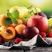 Frische Sommerfrüchte wie Äpfel, Trauben, Beeren, Birnen und Aprikosen auf einem Tisch