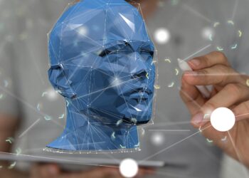 Hand mit Stift zeichnet vor einer blauen Schädelbüste Linien als Verbindung verschiedener Lichtpunkte