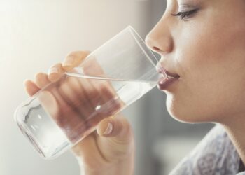 Junge Frau trinkt Wasser.