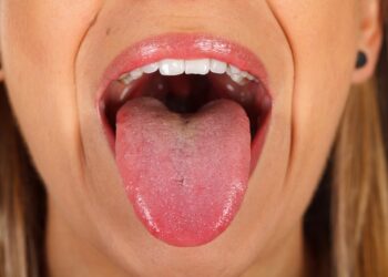 Eine Frau zeigt ihre Zunge.