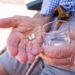 Senior mit zwei Tabletten und einem Glas Wasser in seinen Händen