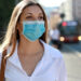 Eine Frau in der Stadt mit Mund-Nasen-Bedeckung