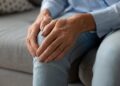 Frau hat Schmerzen im Knie.