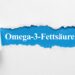 De Schriftzug Omega-3-Fettsäuren unter aufgerissenem Papier