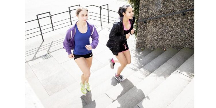 Zwei Frauen joggen eine Treppe hinauf.