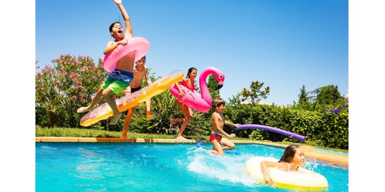 Fünf Kinder springen in einen Swimmingpool.