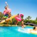 Fünf Kinder springen in einen Swimmingpool.