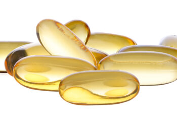 Einige Vitamin-D-Pillen vor einem weißen Hintergrund.
