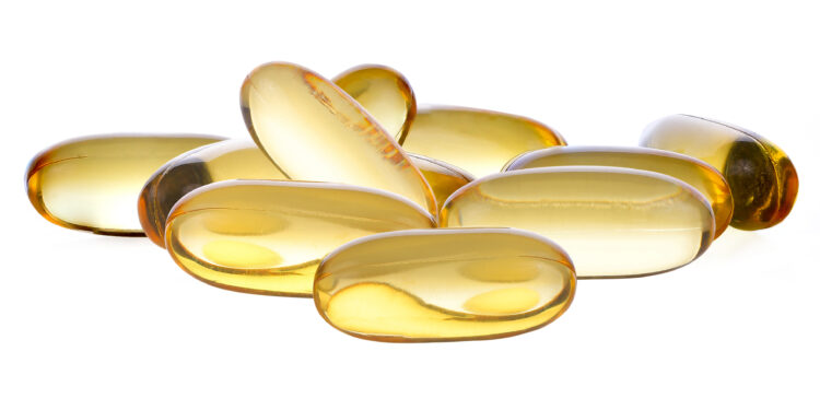 Einige Vitamin-D-Pillen vor einem weißen Hintergrund.