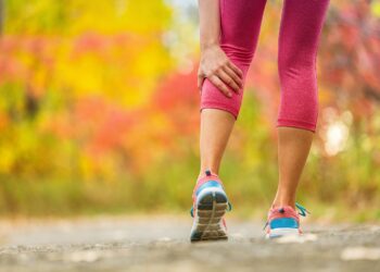 Frau erleidet beim Joggen einen Wadenkrampf