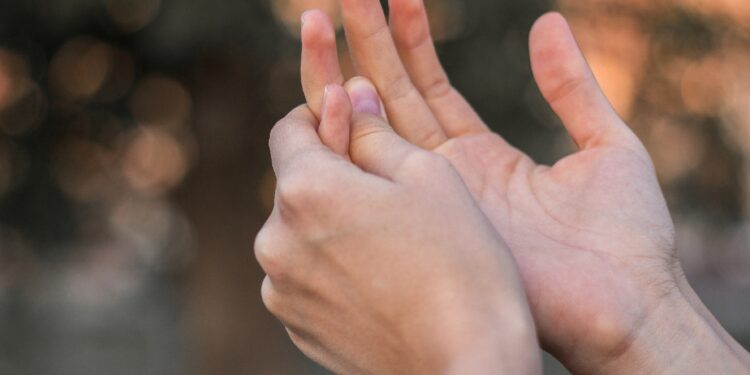 Junge Frau hält ihre schmerzende Hand