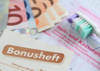 Heil- und Kostenplan mit einem Bonusheft, einer Zahnbürste und mehrere Euroscheine