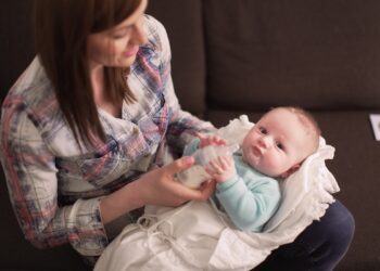 Eine Frau füttert ein Baby mit einer Flasche.