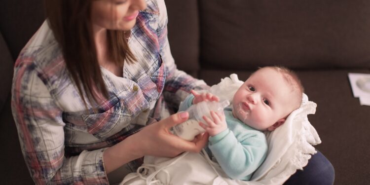 Eine Frau füttert ein Baby mit einer Flasche.