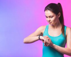 Frau schaut auf ihren Fitness-Tracker