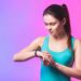 Frau schaut auf ihren Fitness-Tracker