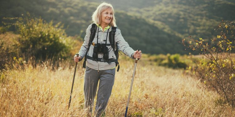 Seniorin mit Fernglas beim Wandern