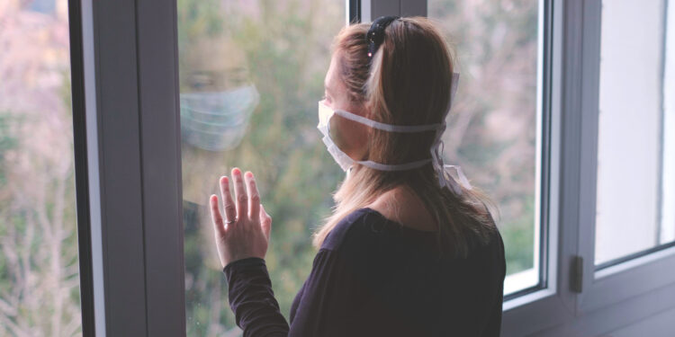 Frau schaut aus dem Fenster.