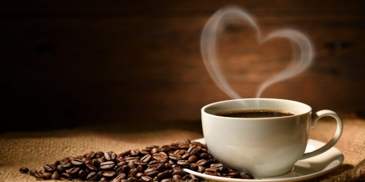 Eine Tasse Kaffee steht auf einer hölzernen Oberfläche.