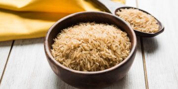 Eine Schüssel und ein Löffel gefüllt mit braunem Basmatireis