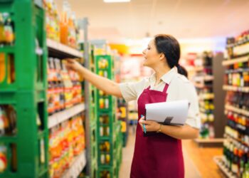 Eine Angestellte im Supermarkt kontrolliert die Getränke.