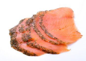 Einige Scheiben graved Lachs vor einem weißen Hintergrund.