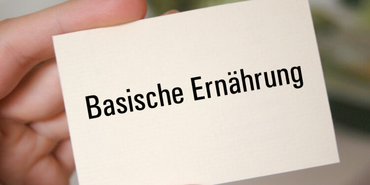 Eine Hand hält eine Karte auf der Basische Ernährung steht