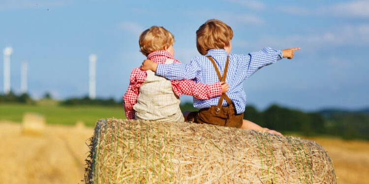 Zwei kleien Jungen sitzen auf einem Heuhaufen